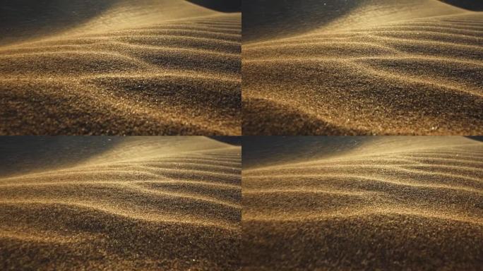 沙漠中的沙尘暴。被风吹走的沙粒的宏观拍摄。相机在夕阳的光线下沿着沙漠中的沙丘表面移动。沙子在风中挥舞