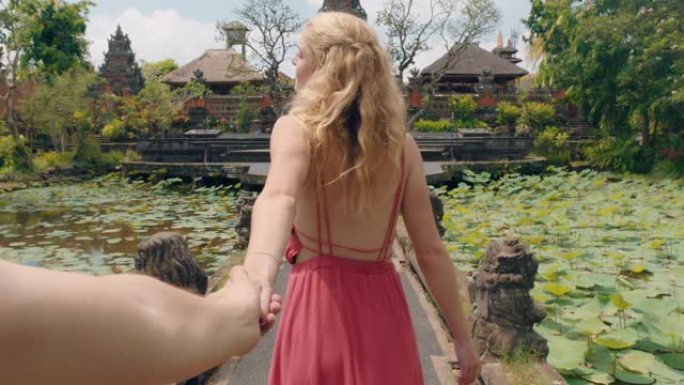 旅游情侣牵手幸福女人带领男友探索萨拉斯瓦蒂寺庙玩得开心印度尼西亚巴厘岛观光文化