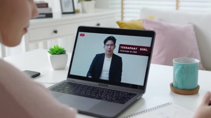 后视图年轻的亚洲女性收听虚拟商务会议网络研讨会、管理市政厅或全体人员在家检疫社交远程会议，以亚洲演讲