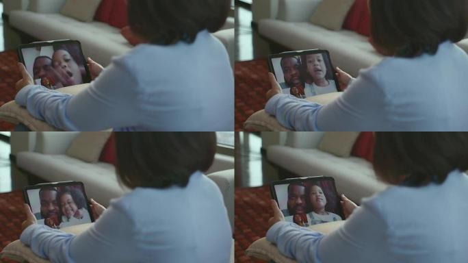 当每个人都必须适应新型冠状病毒肺炎流行的情况时，母亲正在平板电脑上与黑人父女交谈，传达出一种新的正常