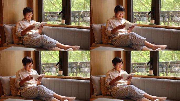 老年女性在家看书女人坐在沙发上靠窗看书读