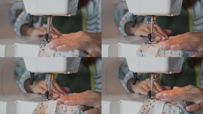 用现代电动缝纫机缝制纺织品的女性手的特写镜头。
