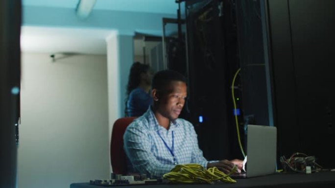 在商务服务器室工作的非裔美国男性计算机技术员笔记本电脑