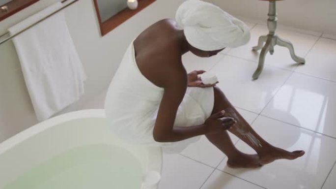 非裔美国迷人女性在浴室涂抹润唇膏的高角度视图