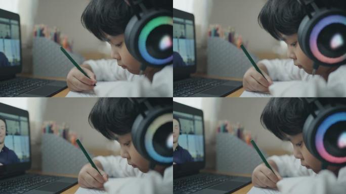 儿童男孩在家与带笔记本电脑的老师进行电子学习