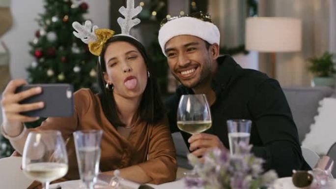 4k视频片段，一对年轻夫妇在家中一起喝酒时享受圣诞节自拍照