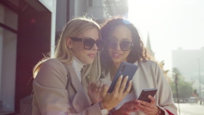 社交媒体影响者，电话和女性朋友在户外一起谈论互联网上的时髦八卦。夏天，人们和内容创作者女孩穿着凉爽的