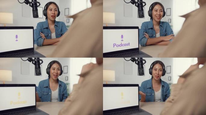 亚洲女孩电台主持人录制播客使用麦克风佩戴耳机采访名人嘉宾内容对话和在她的房间里听。