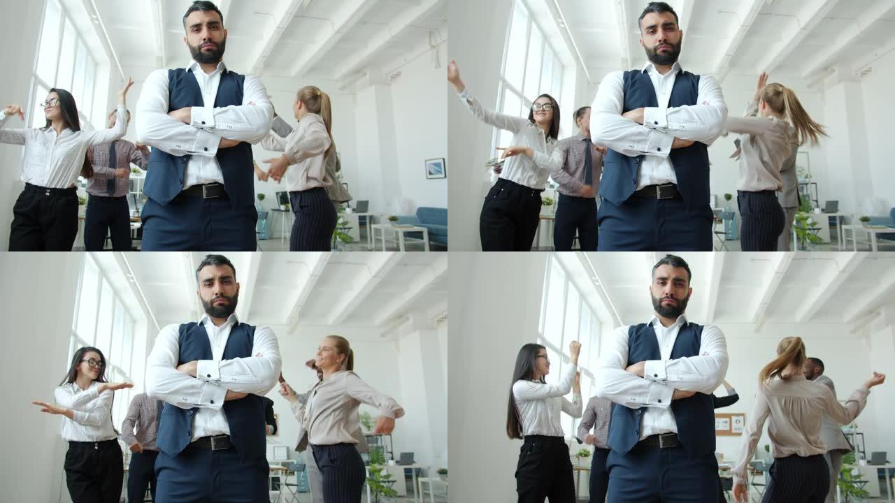 当人们跳舞时，严肃的企业主站在公司活动上的低角度视角