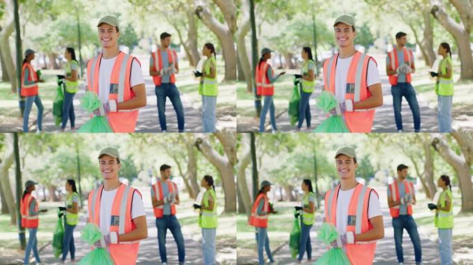 一个年轻人与生态友好社区一起打扫公园的肖像。负责任的理事会工作人员，活动人士或志愿者穿着橙色和黄色背