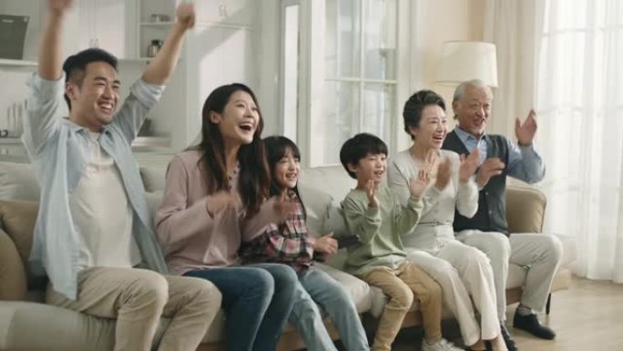三代亚洲家庭在家观看电视直播体育直播