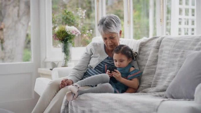 可爱的小女孩展示奶奶如何使用智能手机教学奶奶现代科技智能孩子在家帮奶奶带手机4k