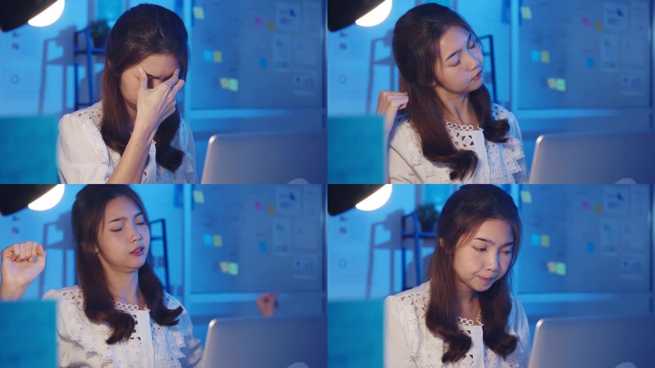 紧张疲惫的年轻亚洲女士使用笔记本电脑努力工作有办公室综合症，在办公室加班时颈部疼痛。