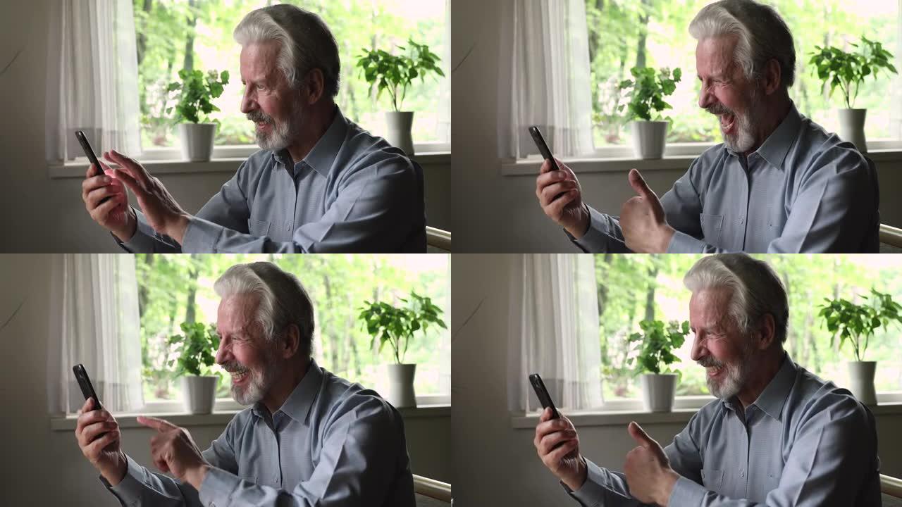 开朗的老人拿着智能手机玩得开心使用现代技术