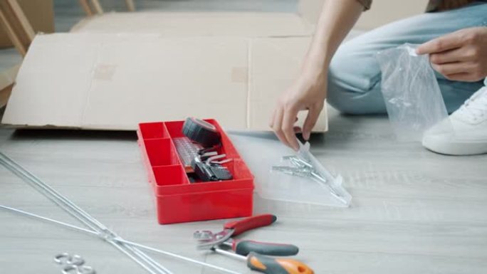 男人在家忙着做家务时，用金属螺丝拍摄男性手的低角度镜头