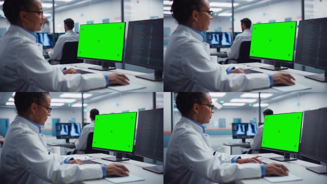 黑人女医生正在医院使用带有绿屏模拟显示的计算机。在现代医院从事生物技术治疗研究的非裔美国科学专业人员