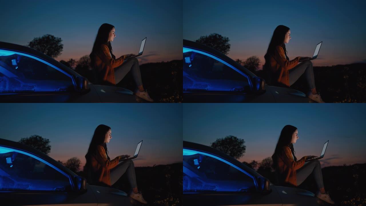 中年黑发女人坐在汽车引擎盖上时使用笔记本电脑，背景为黄昏天空，慢动作