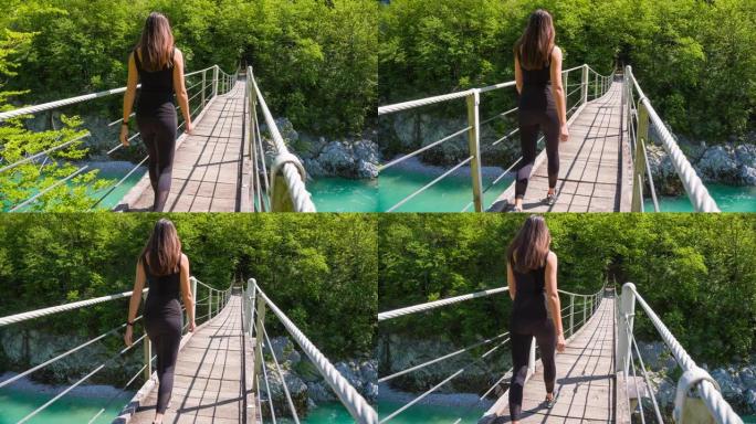 年轻女性走过木制吊桥