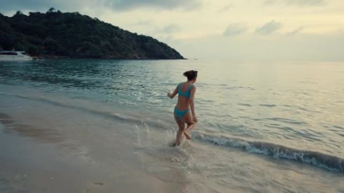 美丽的女人在热带岛屿海滩上玩得开心。