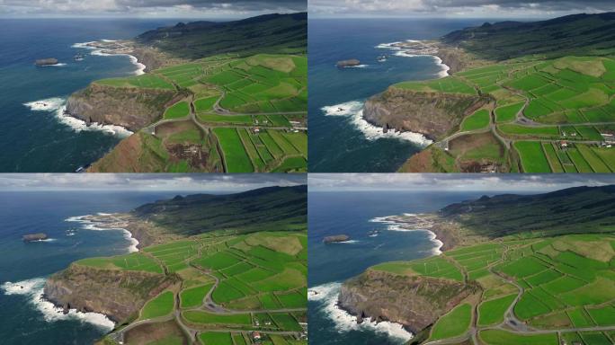 葡萄牙亚速尔群岛圣米格尔岛。飞越一个有绿色田野的农场。大西洋陡峭的海岸。多云的地平线。空中射击，UH