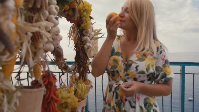 SLO MO女人从阿马尔菲海岸路边的一个摊位上购买新鲜的橙子