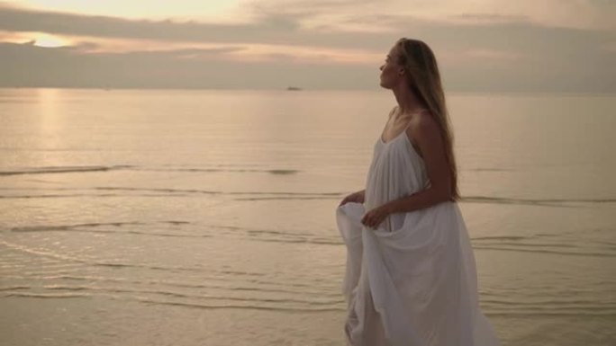 穿着白色连衣裙的女人在海边散步