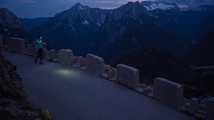 健康导向的女人晚上在山口路上徒步旅行