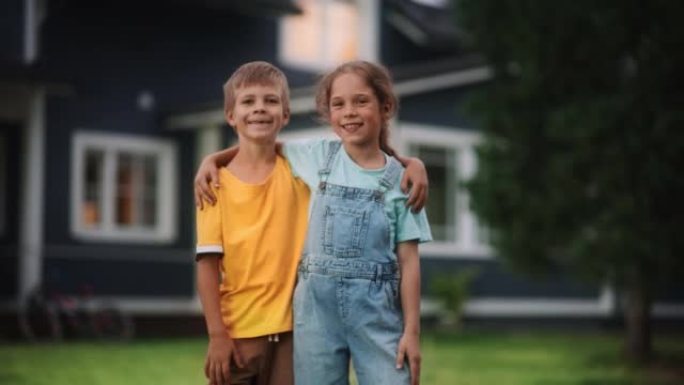 年轻快乐的哥哥和姐姐站在乡间别墅前，互相拥抱，看着镜头，微笑着。两个孩子享受童年和友谊。