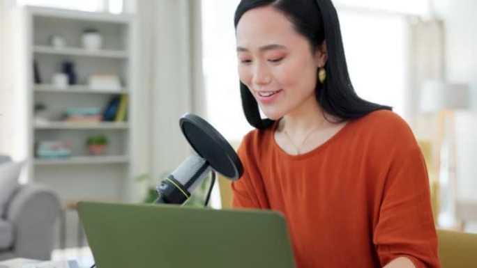 播客，麦克风和现场直播，一位亚洲女性主持人在录制或广播时在笔记本电脑上打字。有影响力的人，媒体和广播