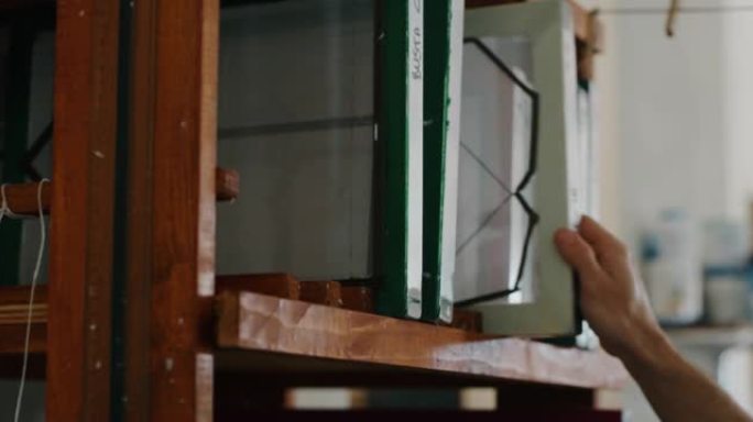 工匠造纸大师的宏正在触摸一张手工纸以控制车间的质量。手工制作的概念，高品质，工匠，意大利制造，传统