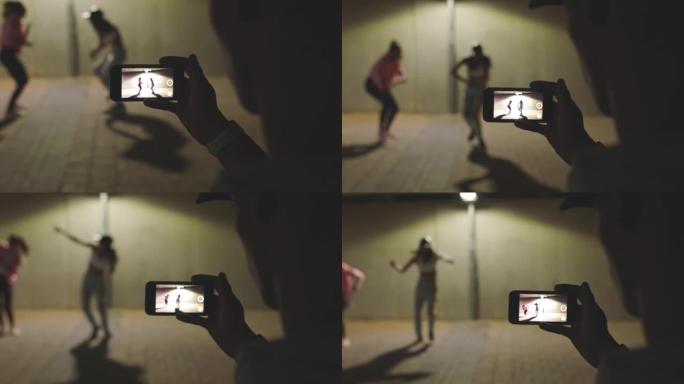 舞蹈挑战，电话录音和女性在城市外使用智能手机摄像头为社交媒体或博客内容跳舞。视频记录，拍摄和拍摄在线