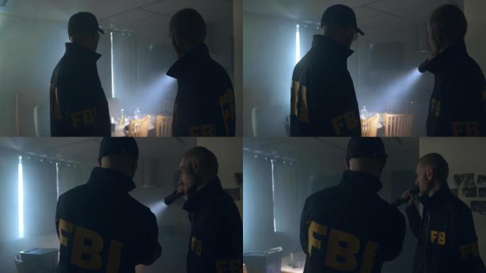 身穿制服的FBI探员拿着手电筒在暗室里讨论案件，我们从后面看到他们的外套上有FBI的大字