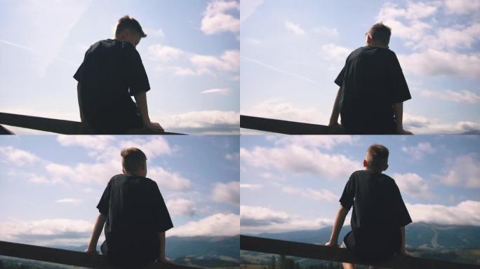 男孩欣赏山脉和多云的天空