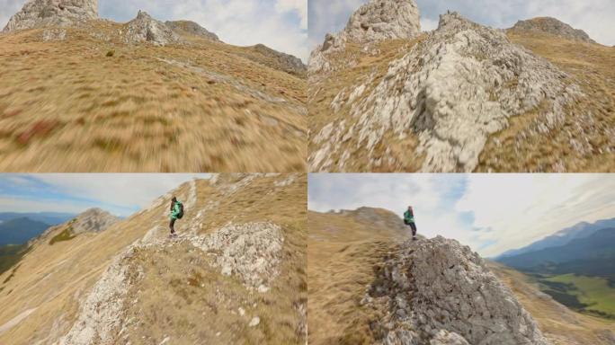 空中女登山运动员欣赏岩石上的景色。FPV无人机