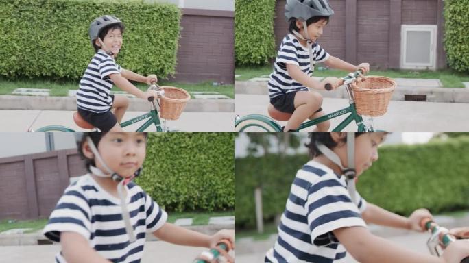 儿童男孩在道路上骑自行车。
