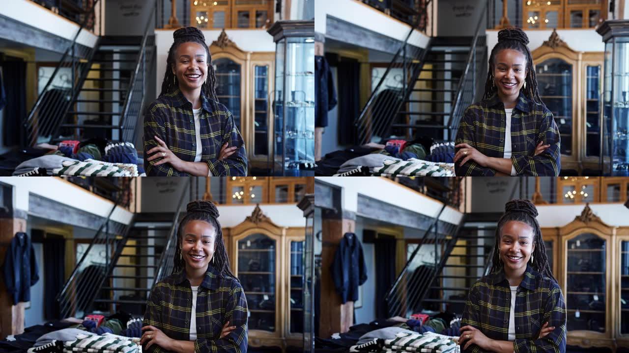 微笑的非洲裔美国女店主站在服装展示前的肖像-慢动作拍摄