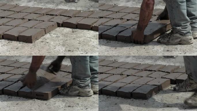 一个在户外制作土坯砖 (泥砖) 的人。特写。低角度视图。
