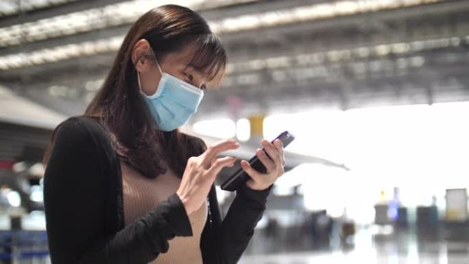亚洲妇女在机场使用智能手机，商务旅行