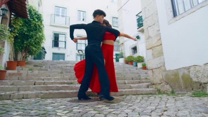 美丽的夫妇在城市老城区的安静街道上跳拉丁舞。在阳光明媚的日子里，两位专业舞者在古老的文化底蕴丰富的旅