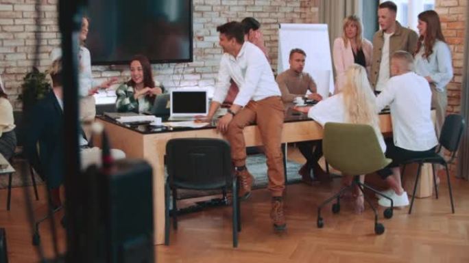 团队合作理念。一群多民族的商人讨论工作，在现代轻型办公室慢动作中产生想法。