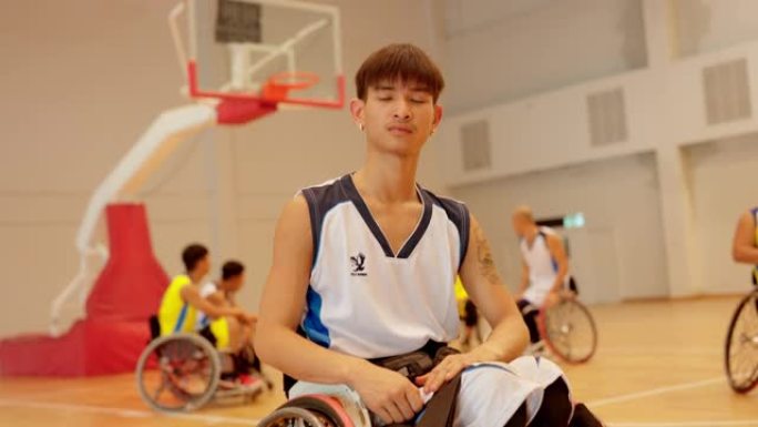 适应性运动员在轮椅上的肖像在篮球场上投篮。
