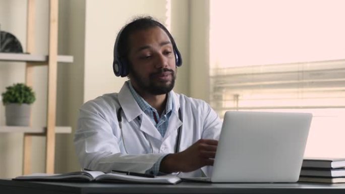 非洲医生坐在工作场所迎接患者开始视频通话