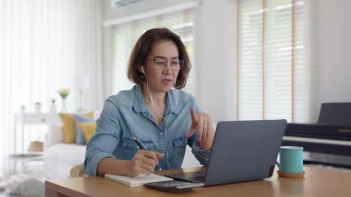 亚洲成年熟女在家工作教学视频会议。