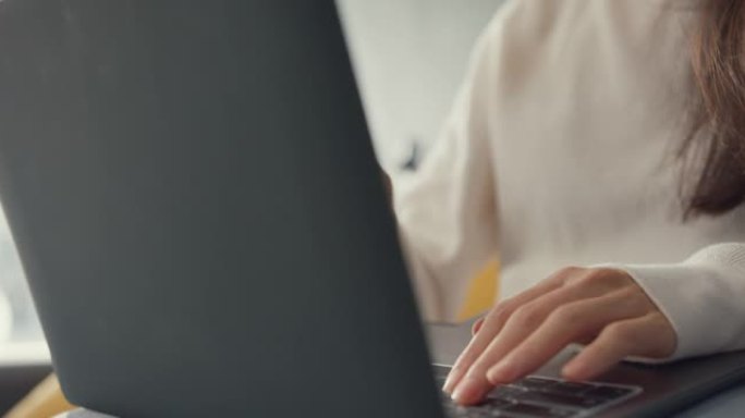 特写自由职业者亚洲女士休闲服使用笔记本电脑在线学习在家里的客厅。从家里开始工作，远程教育，社交距离，