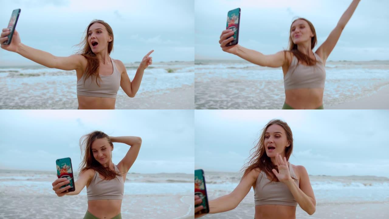 美丽的女孩在海滩上用智能手机自拍