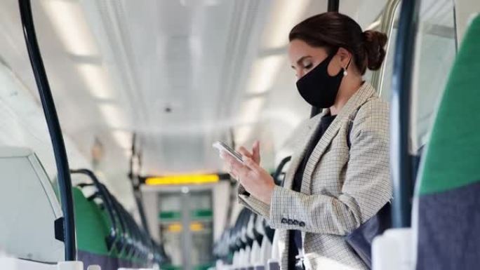 大流行期间，女商人戴着PPE口罩站在火车车厢里