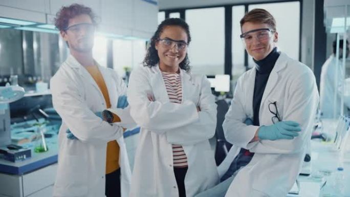 医学实验室由三名年轻成功的科学家组成。美丽的黑人女性，英俊的拉丁人和高加索男性科学家看着相机微笑。中