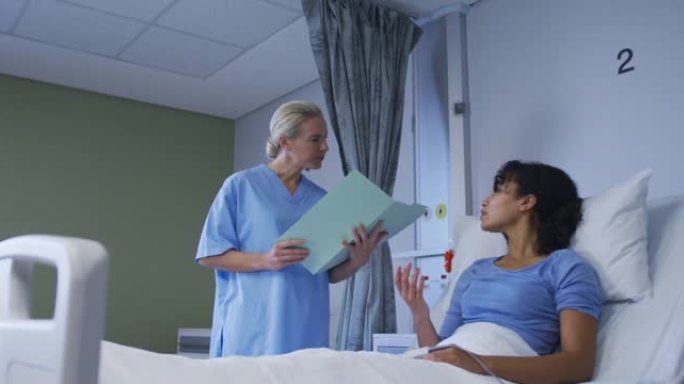 多元化的女医生与坐在医院病床上的病人交谈