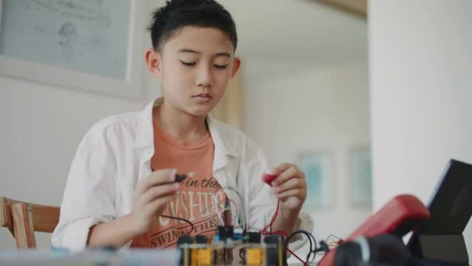男孩编程在科学课上建造机器人汽车