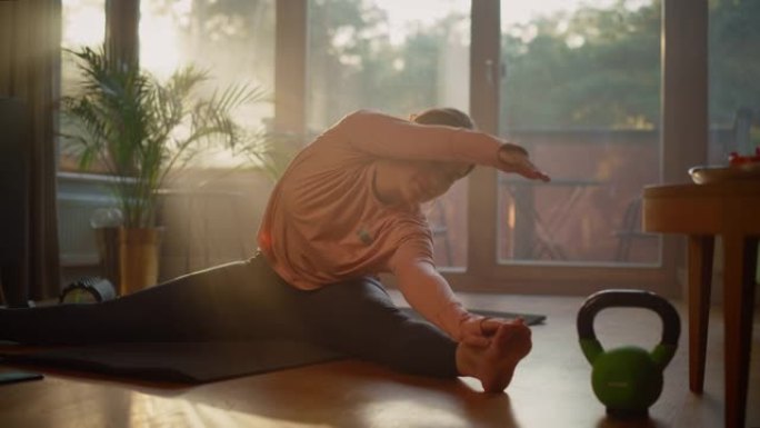 漂亮的女孩在家做健身运动。正宗的华丽大码女人做锻炼，腿筋拉伸，瑜伽。健康健康自信的女性在晴天做日常运